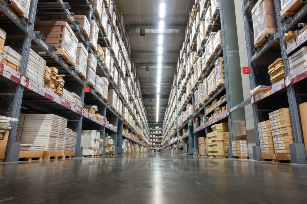 A vast warehouse interior with towering shelves stocked meticulously with boxes and goods.