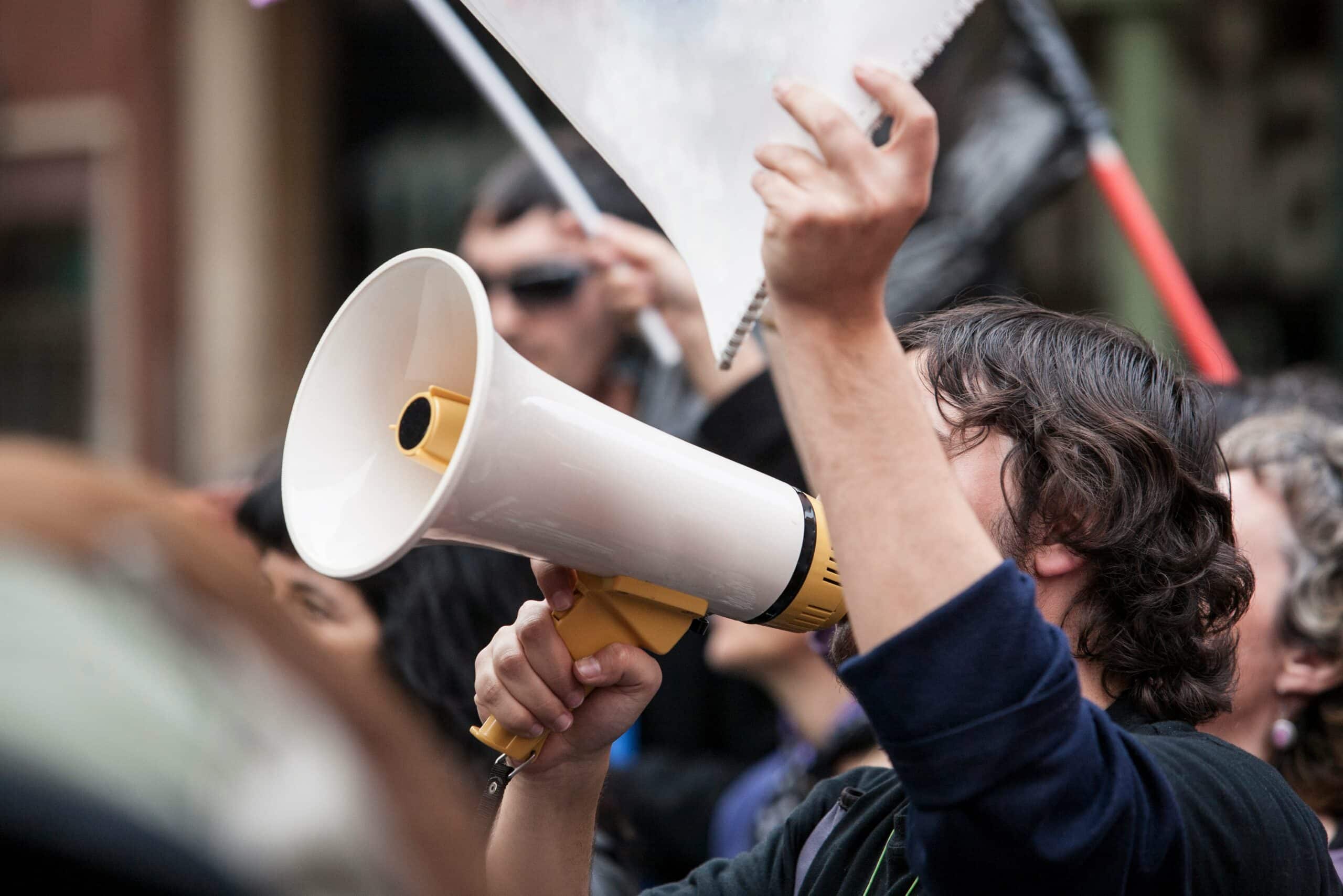A labor strike scene in Palo Alto, secured by Global Risk Solutions, with an activist using a megaphone.