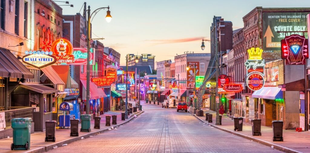 Beale Street in Memphis illuminated by neon signs at twilight.