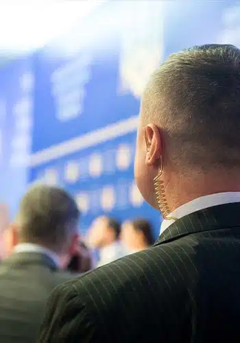 Private Event Security Guard from Global Risk Solutions providing close protection services. Agent is wearing a security ear peace and is staying vigilant on the crowd and clients.
