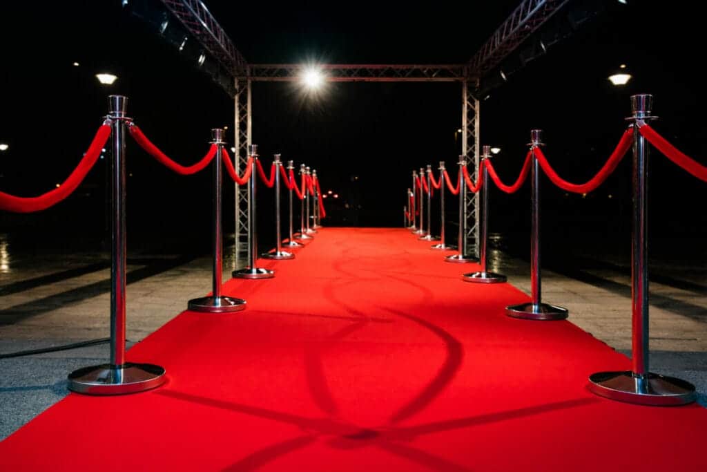 Red carpet event setup at night with velvet ropes and stage lights, secured by Global Risk Solutions, Inc.