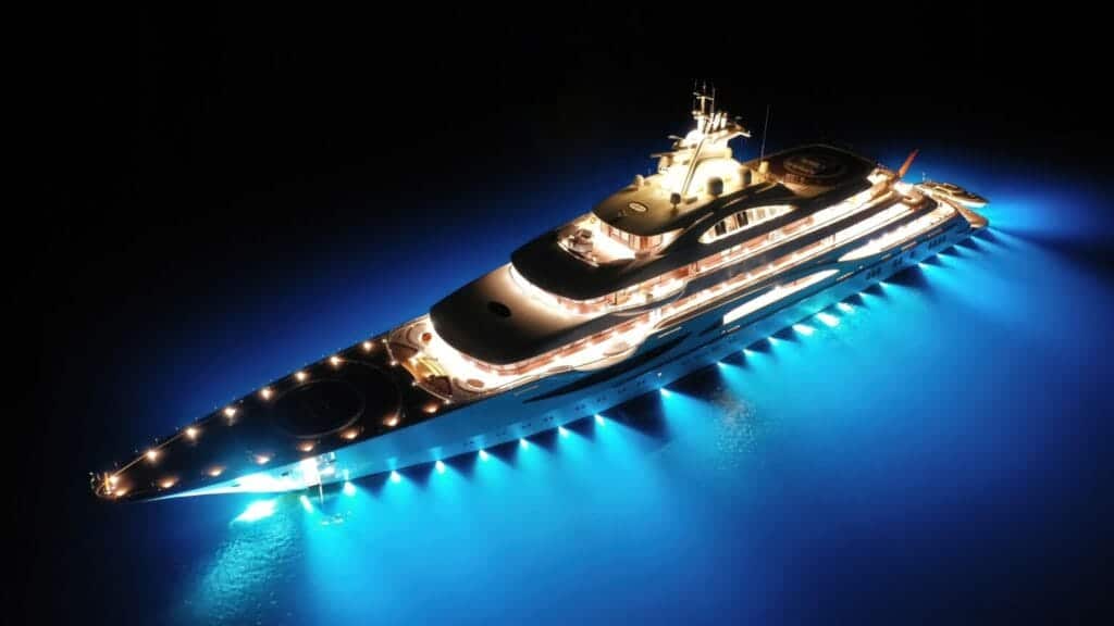 Luxurious private yacht illuminated at night on open water, secured by Global Risk Solutions, Inc.