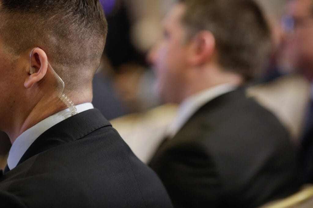 Security personnel at an event wearing an earpiece, focused on maintaining the safety of the attendees, provided by Global Risk Solutions, Inc.