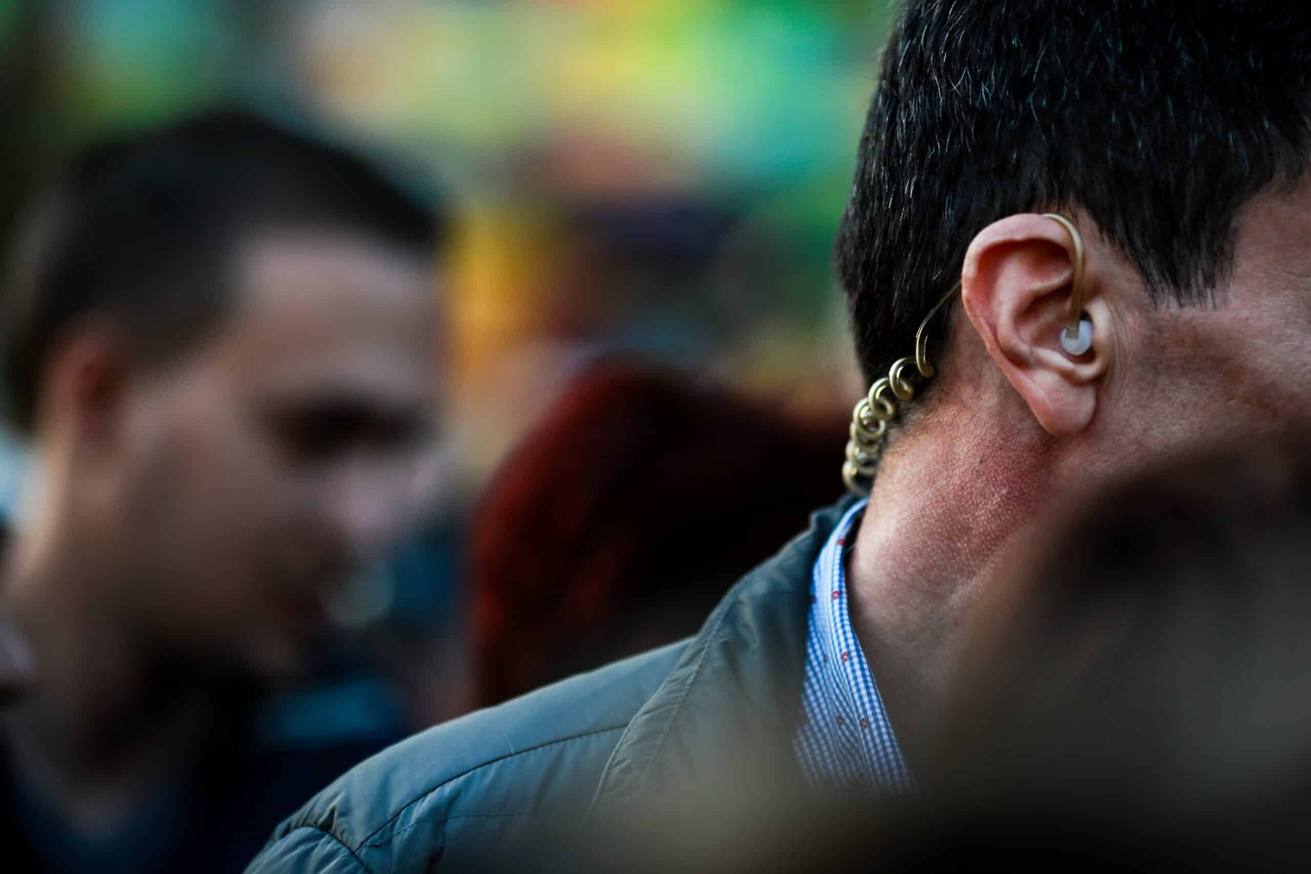 Close-up of a security agent with an earpiece, symbolizing the covert protection services provided by Global Risk Solutions, Inc.
