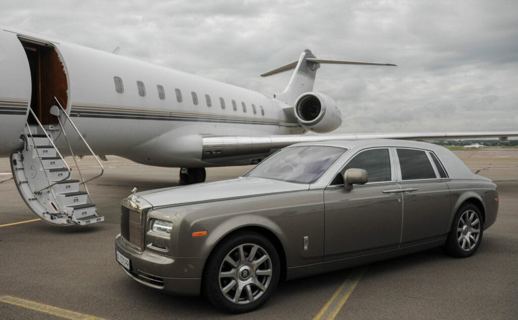 Rolls-Royce parked beside a Private Jet on an air strip