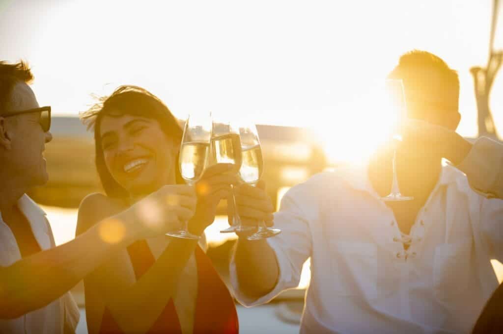 Happy family celebrating on a private yacht toasting with wine glasses