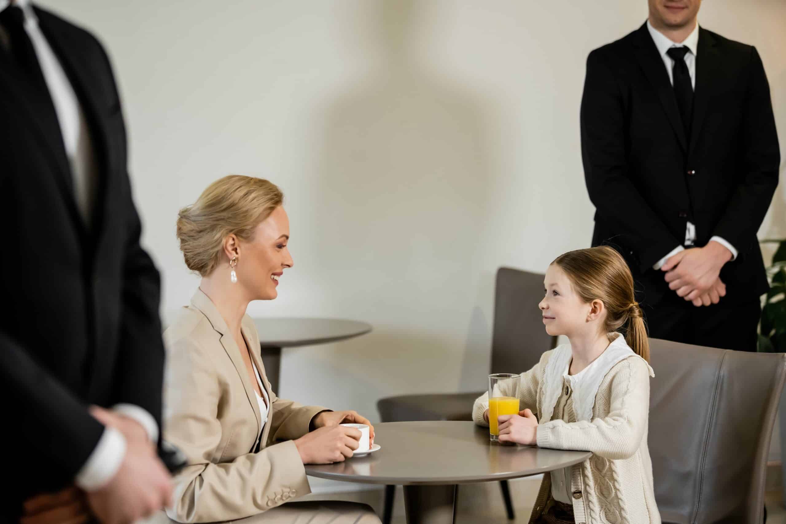 A mother and child enjoying a relaxed conversation with a professional security agent discreetly in the background, emphasizing the personal security services provided by Global Risk Solutions, Inc.