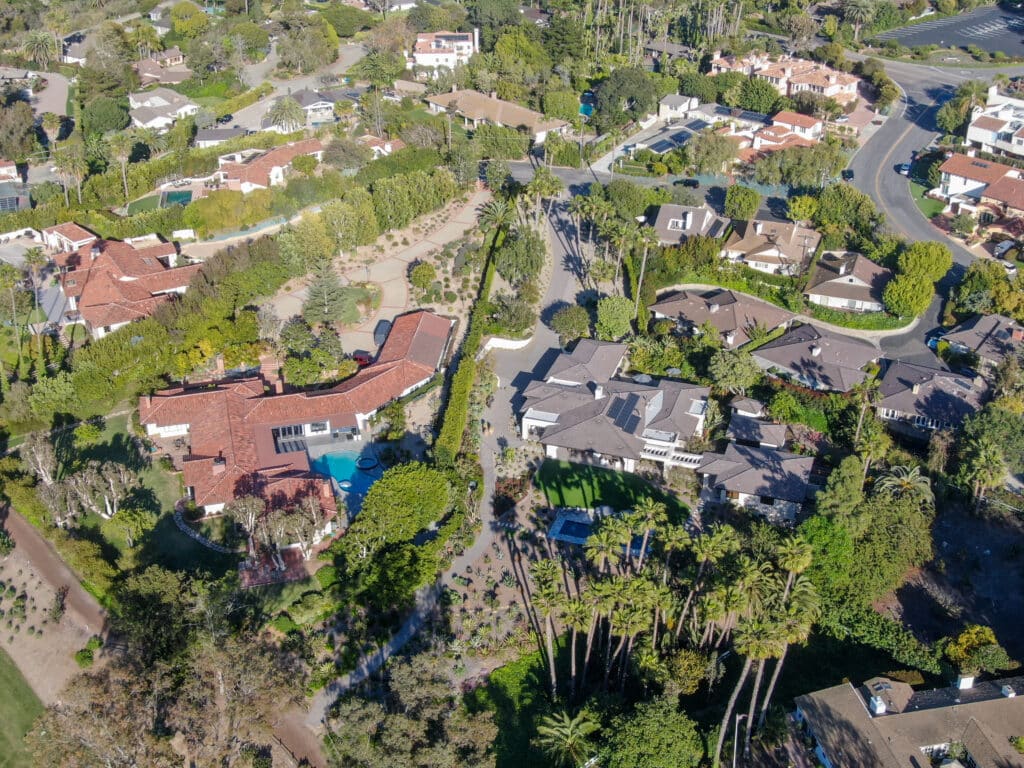 Aerial view of Rancho Santa Fe showcasing luxurious estates with pools and lush landscaping.