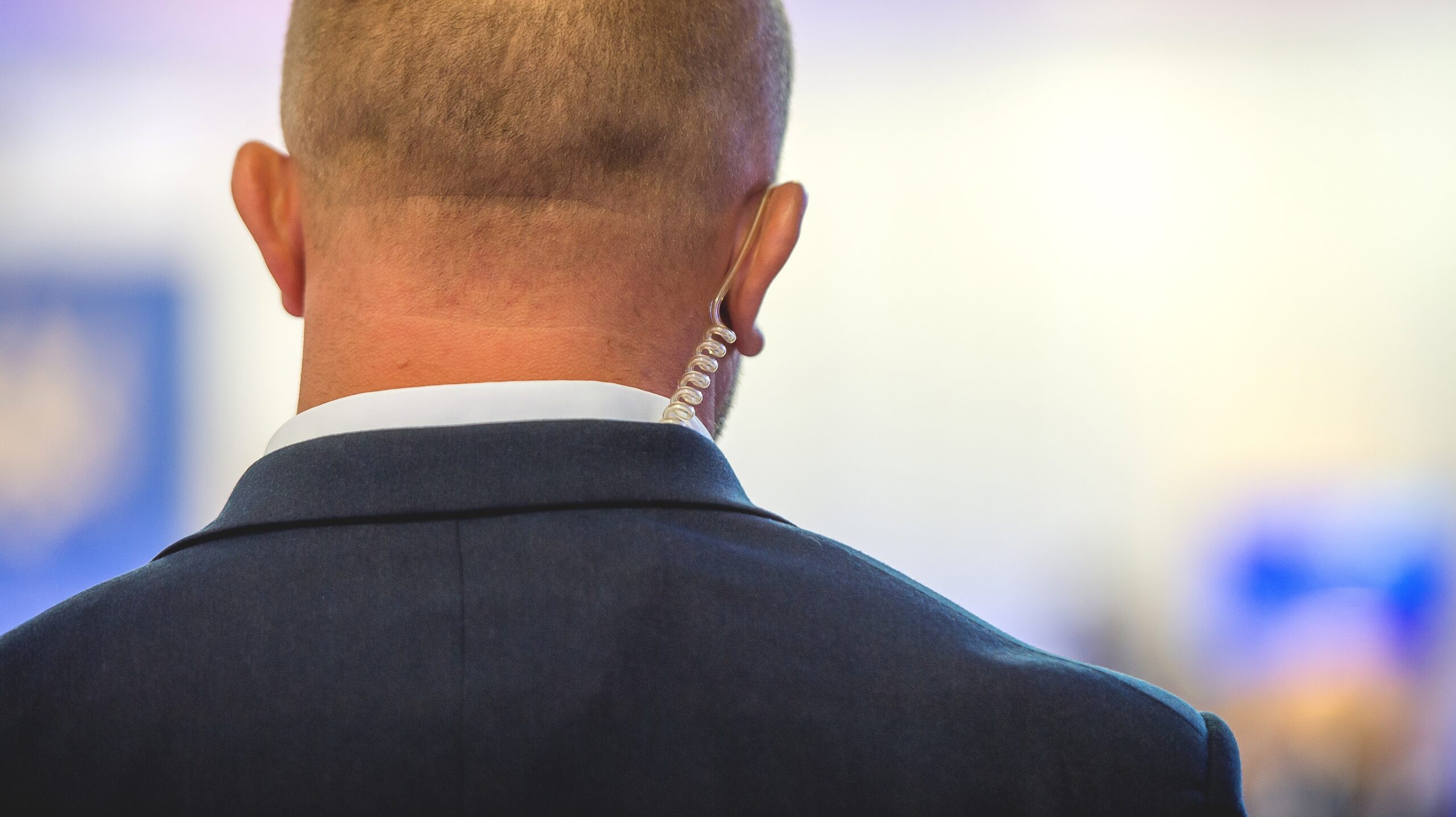 A security agent from Global Risk Solutions, Inc. with an earpiece, showcasing professionalism and readiness to act, symbolizing elite executive protection services.