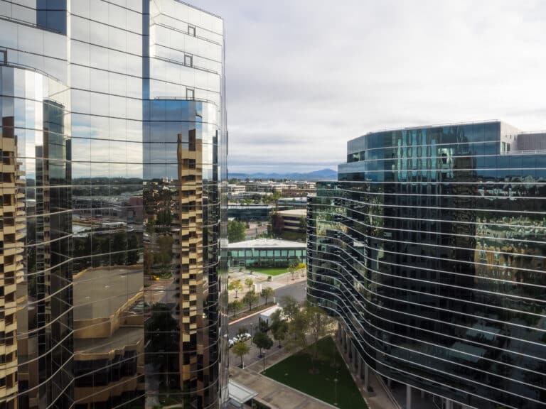 Modern corporate buildings in San Diego, La Jolla, with reflective glass facades and a view of the cityscape.