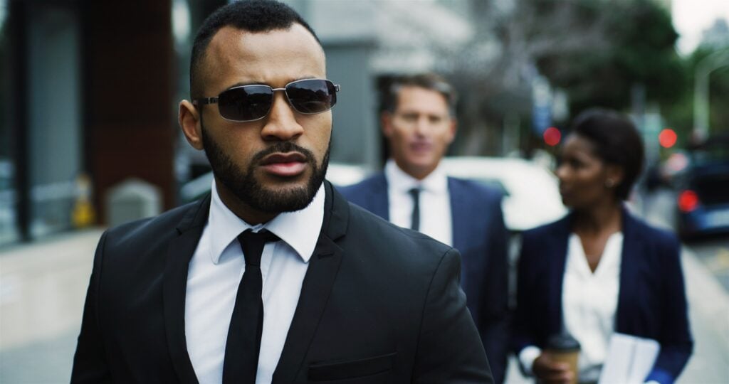 Close Protection Agent walking alongside business professionals in a city environment, providing discreet and professional security services.