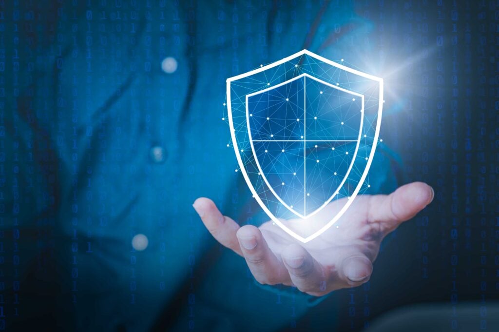 A glowing digital shield held in a hand, symbolizing the Future of Close Protection with advanced security technologies and innovative strategies.
