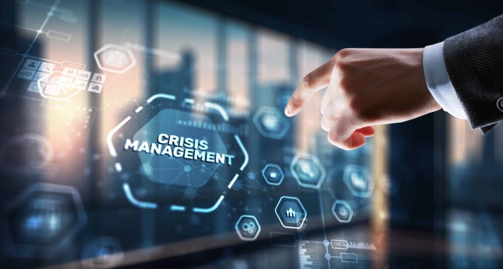 Crisis Management And Emergency Response: Key Protocols In Executive Protection 11 A hand pointing at a digital screen displaying "Crisis Management," representing technological integration in crisis management in executive protection.