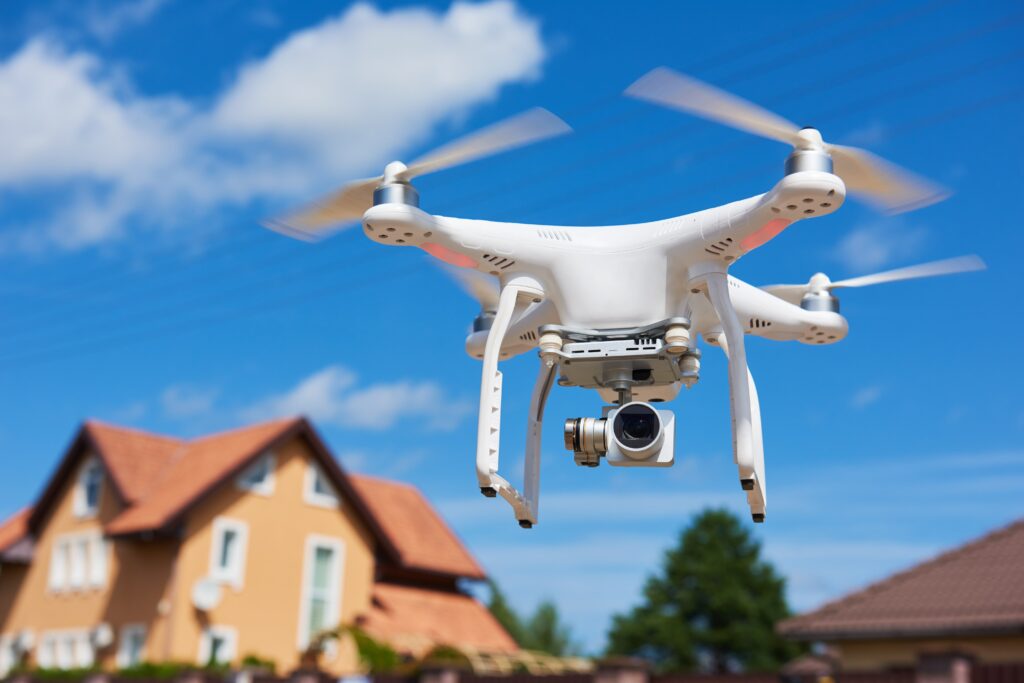 The Role Of Drones In Executive Protection: Enhancing Perimeter Security And Surveillance 4 A drone equipped with a camera flying over a residential property, showcasing the use of drones in executive protection.