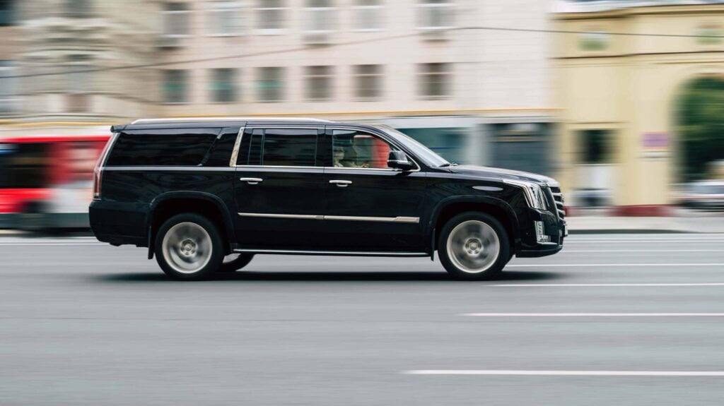 Securing Executive Travel: Best Practices For Protecting Executives On The Move 4 A black SUV driving swiftly through an urban area, symbolizing transportation security in securing executive travel.