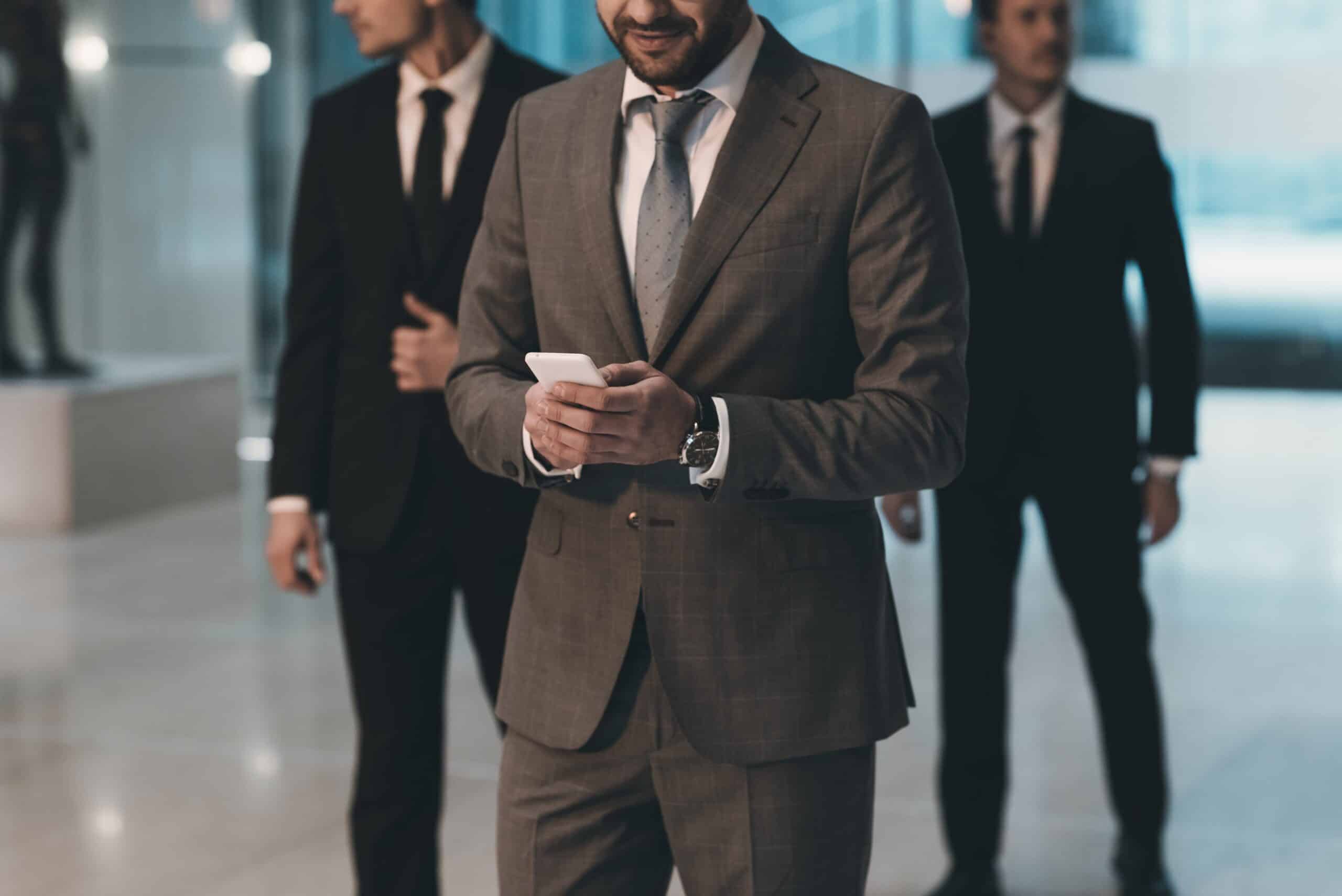 Close Protection Drills showing agents in business attire securing a VIP in a hotel lobby with vigilant posture and communication gear.