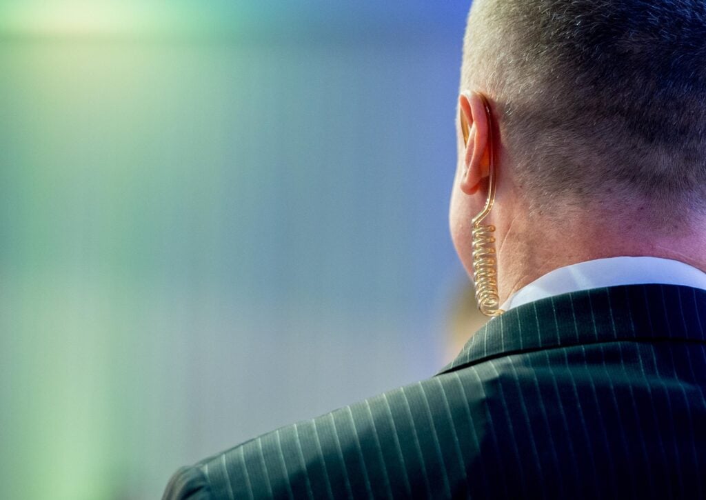 Close-up of a security agent with an earpiece representing How Much Security Is Needed for Your Event and the importance of professional event protection planning.