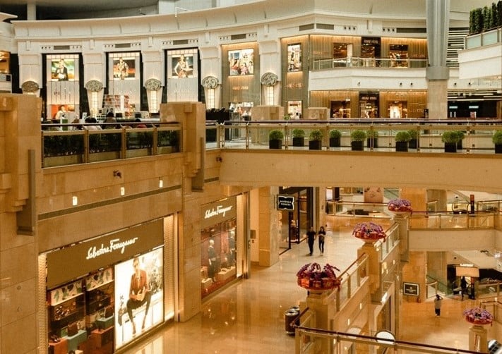 Multi-level luxury shopping mall implementing retail theft prevention strategies with visible security and open floor design